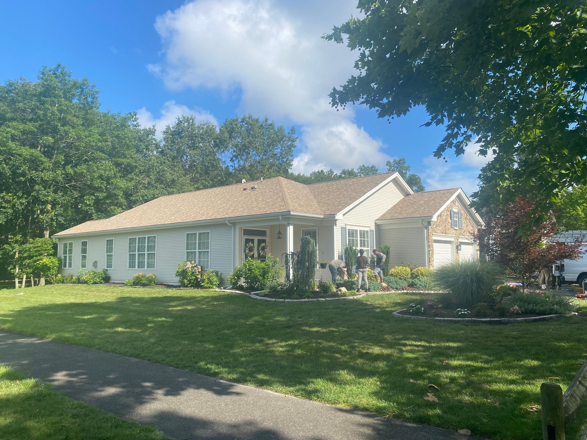 A house with a blue siding and white trim is sitting on top of a dirt field.