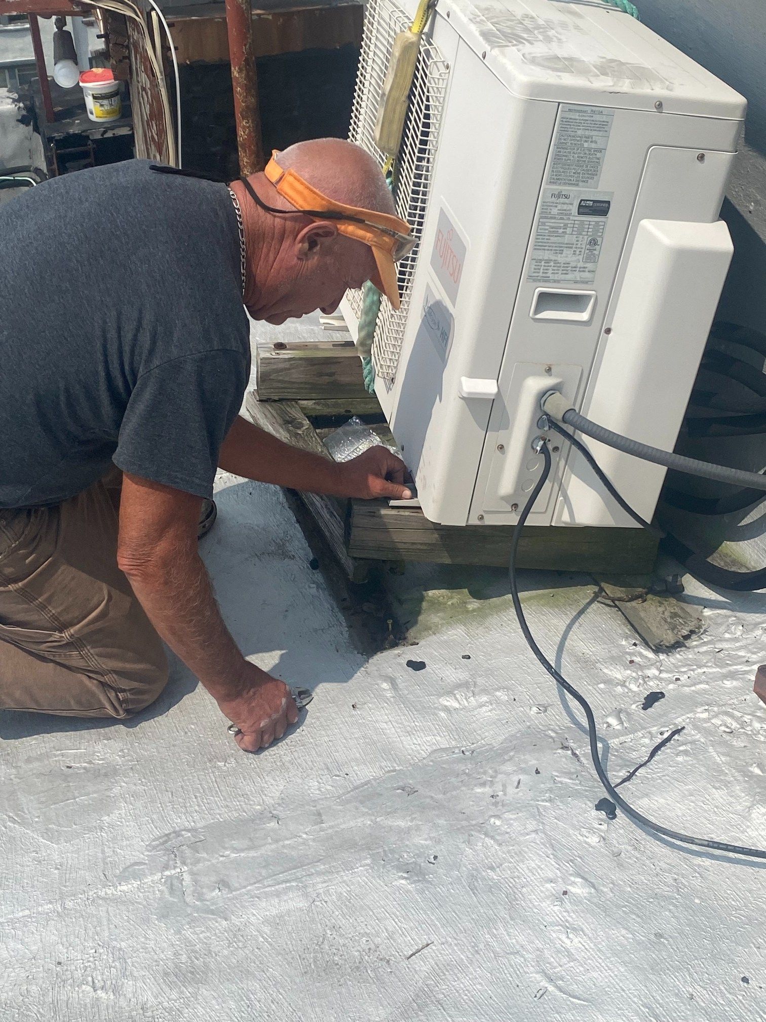 Two men are working on the roof of a house.