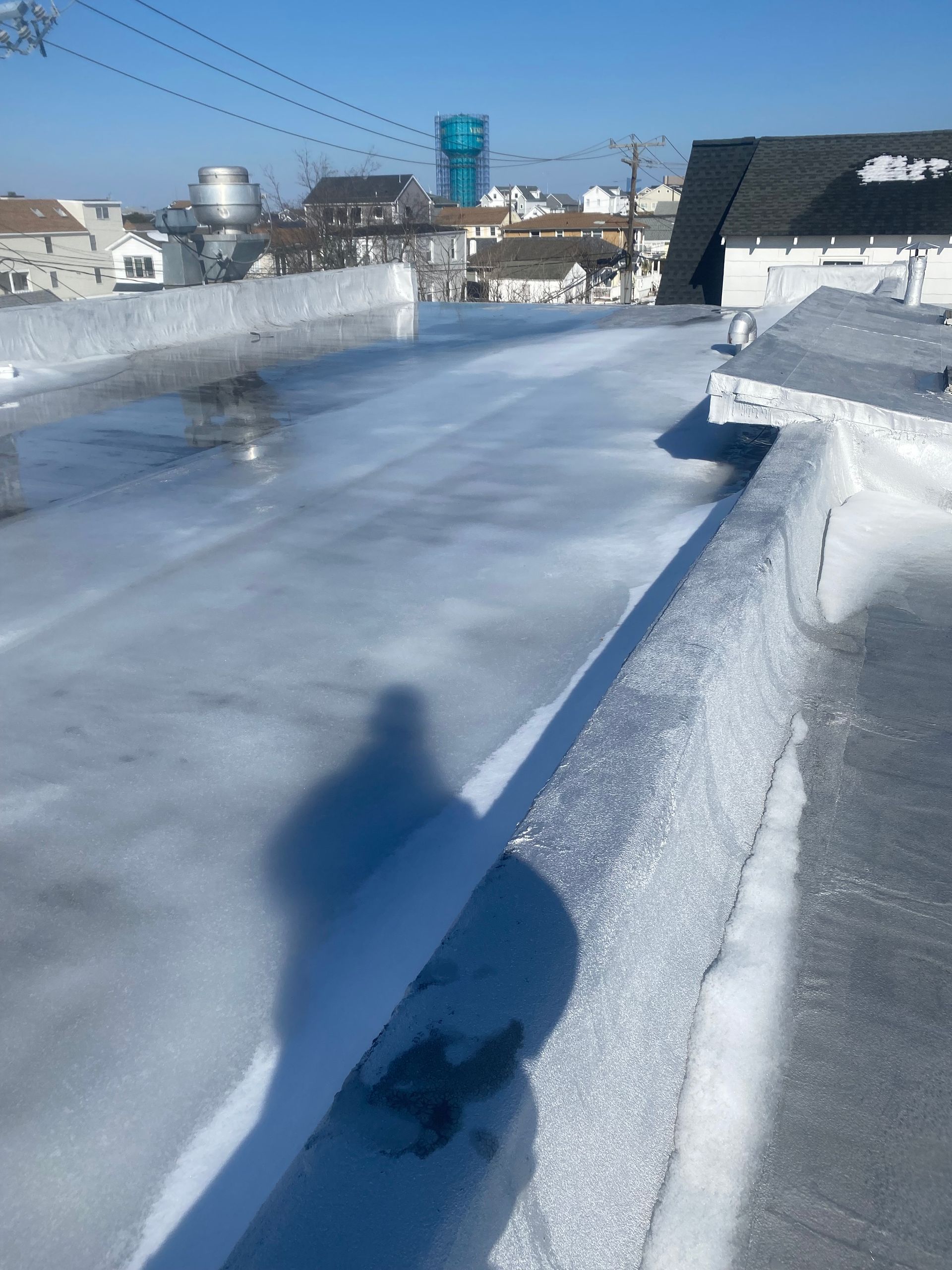 Frozen rooftop with a snow-covered walkway and a bright blue sky