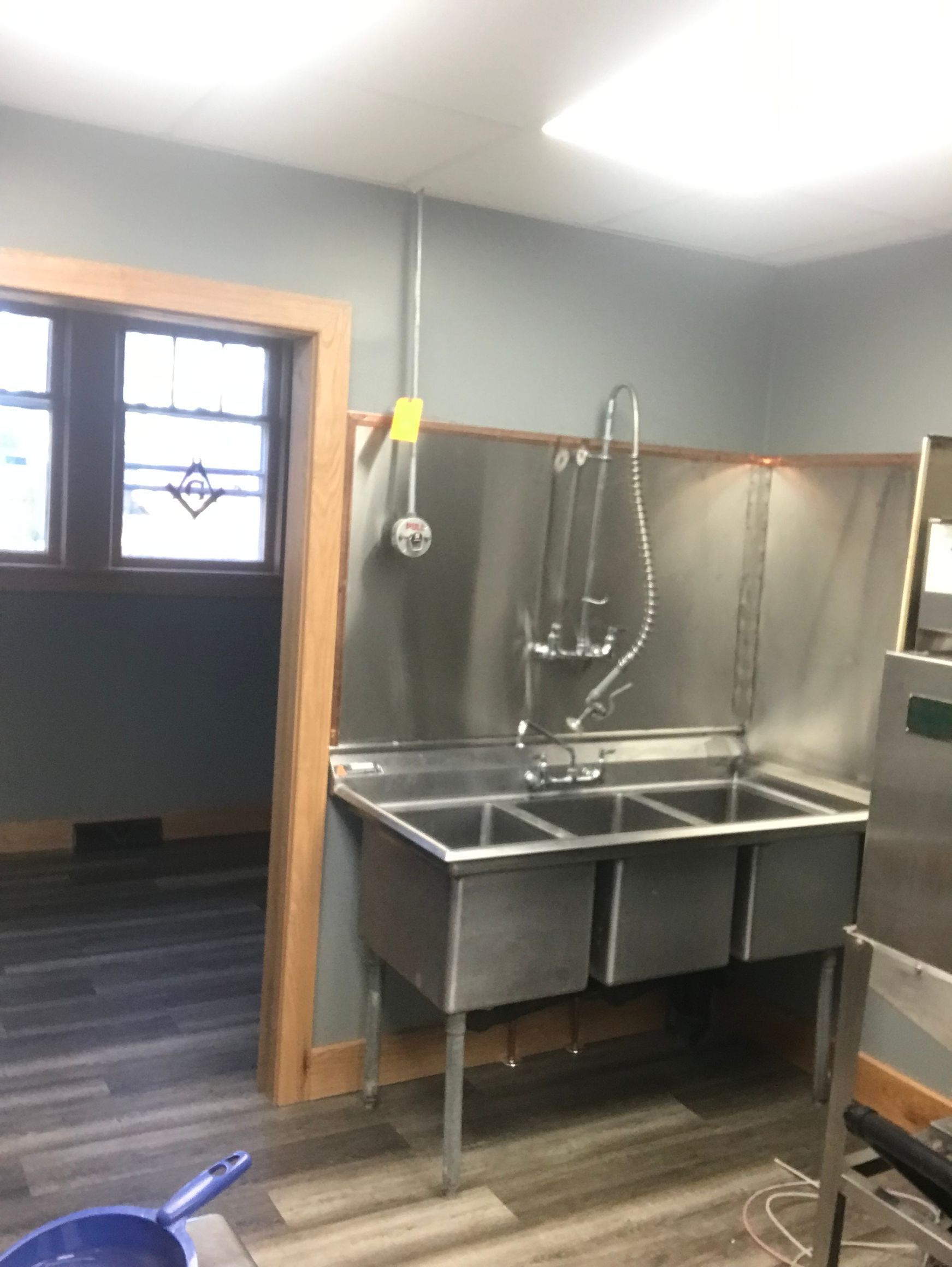 A kitchen with a stainless steel sink and a window