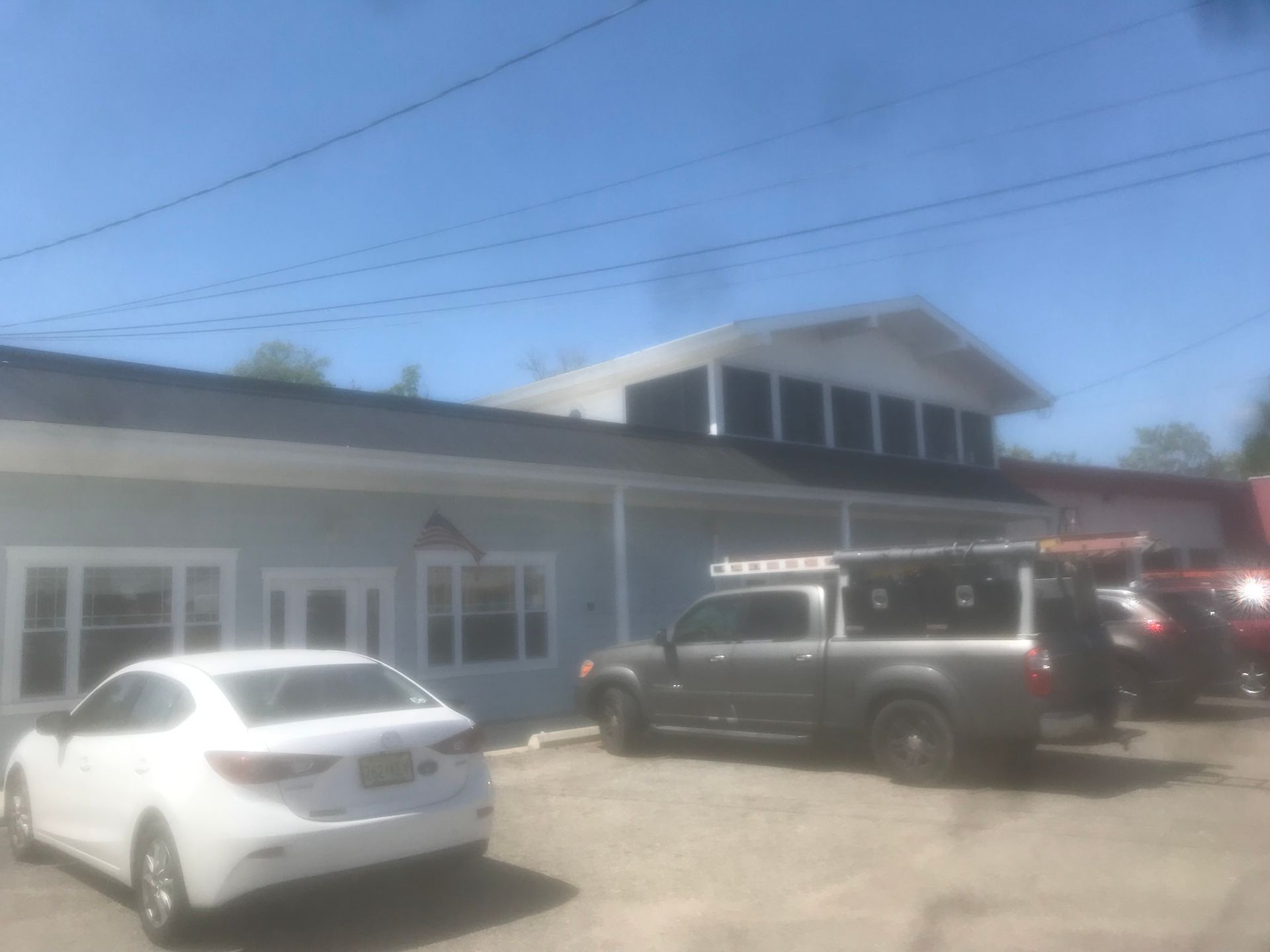 A white car is parked in front of a building