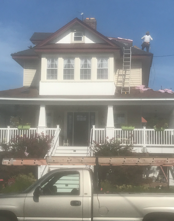 A white truck is parked in front of a large house
