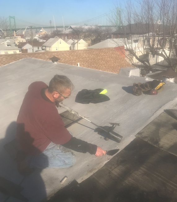 A man is working on the roof of a building.