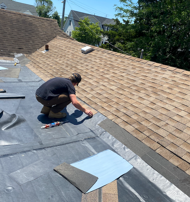 A man is working on the roof of a house