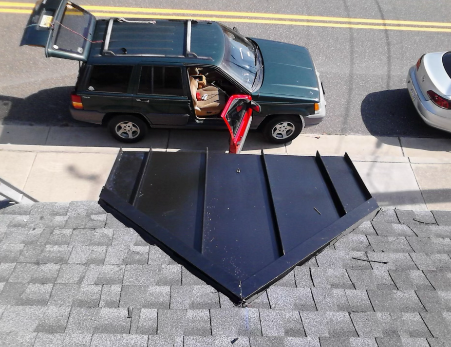 A green suv is parked on the side of the road with its trunk open