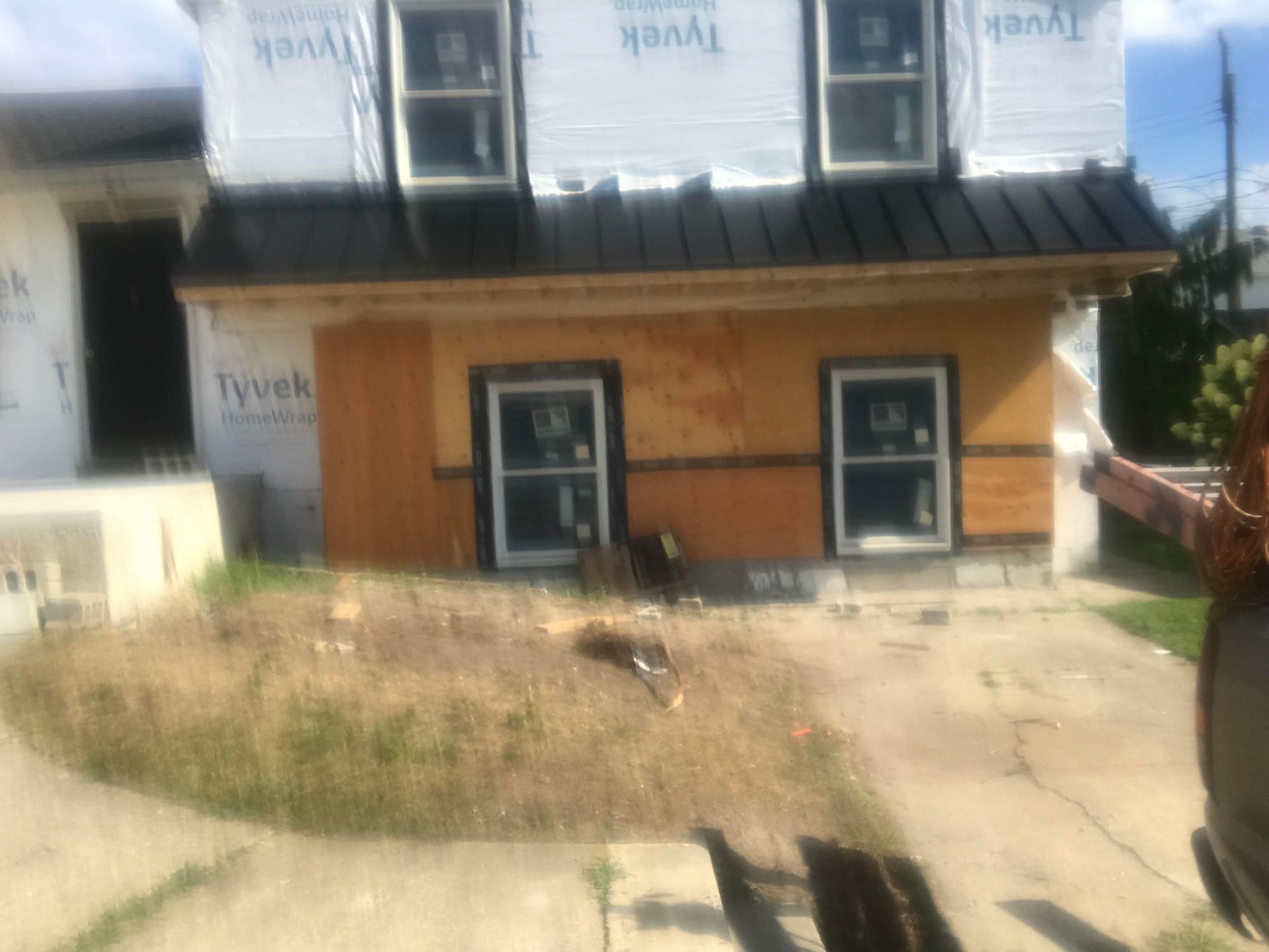 A house is being built with a black roof and windows.
