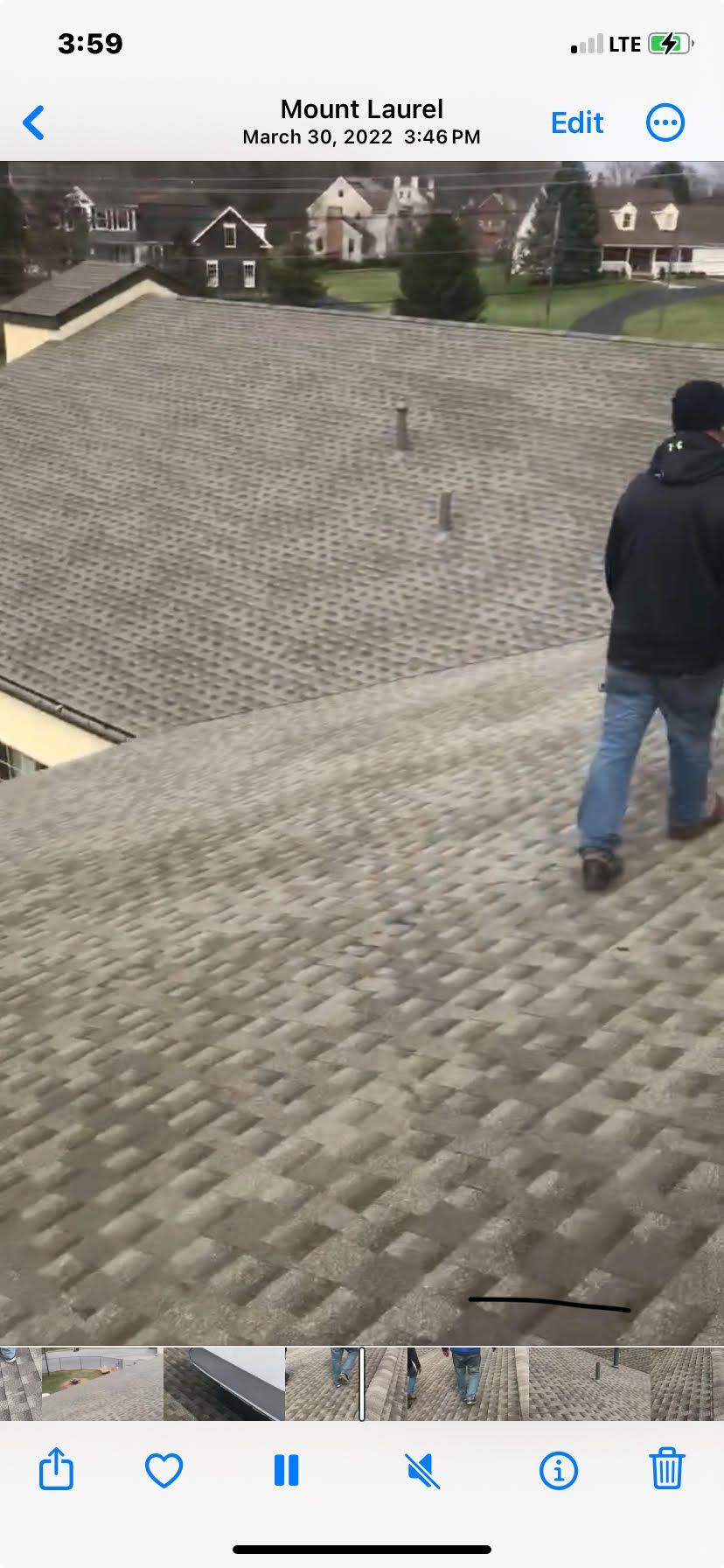 A man is standing on the roof of a house.