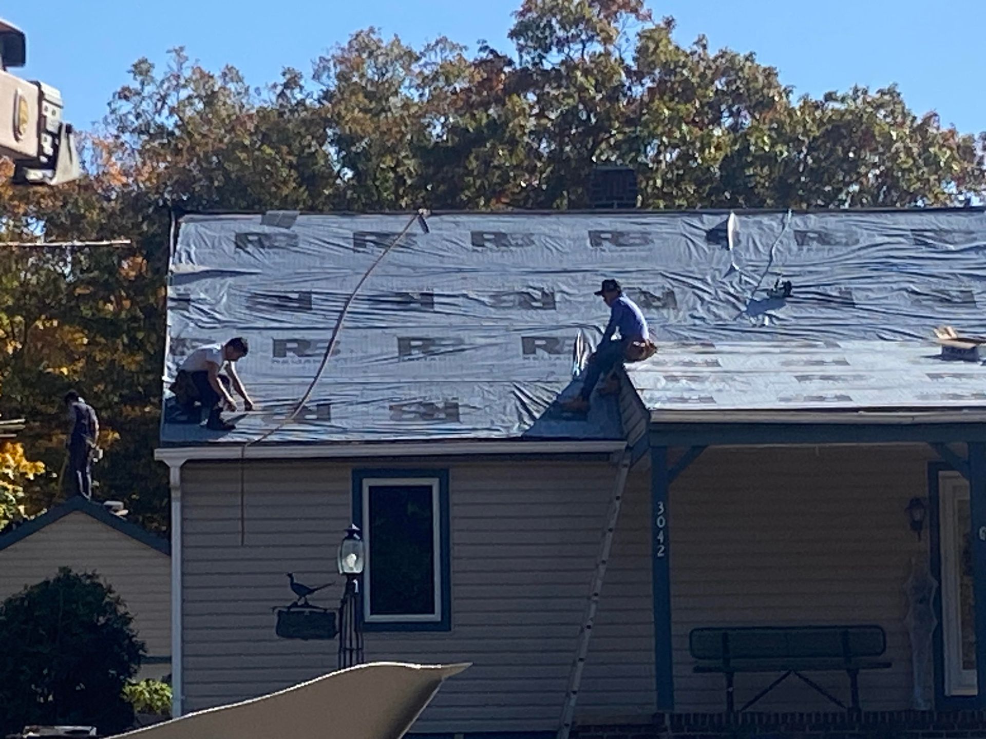 Two men are working on the roof of a house.