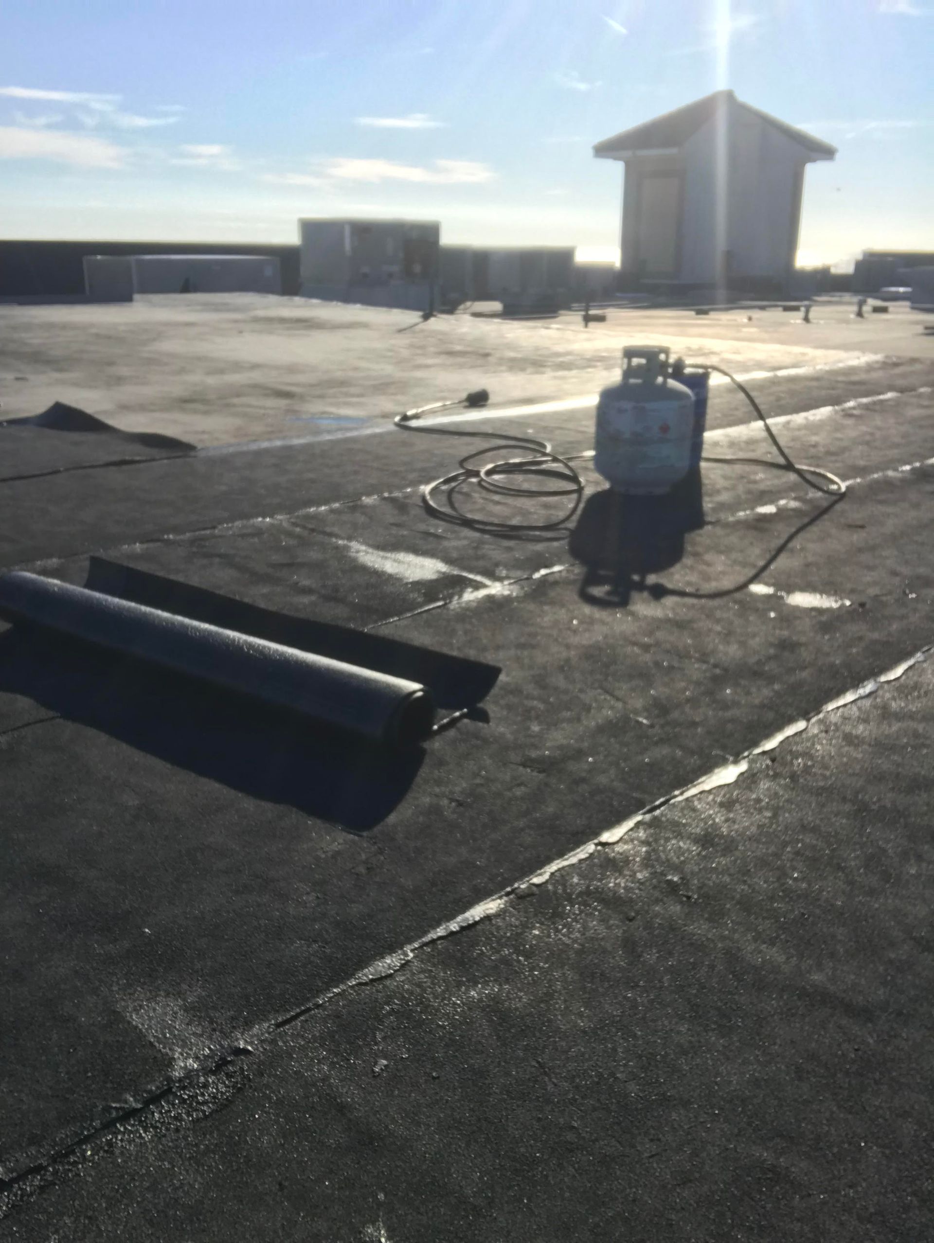 A propane tank is sitting on the roof of a building.