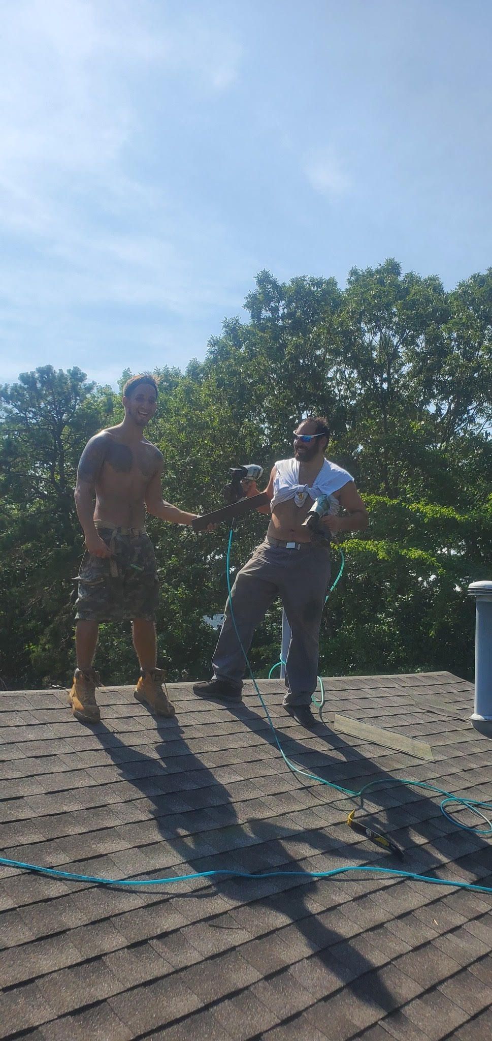 Two men are standing on top of a roof.