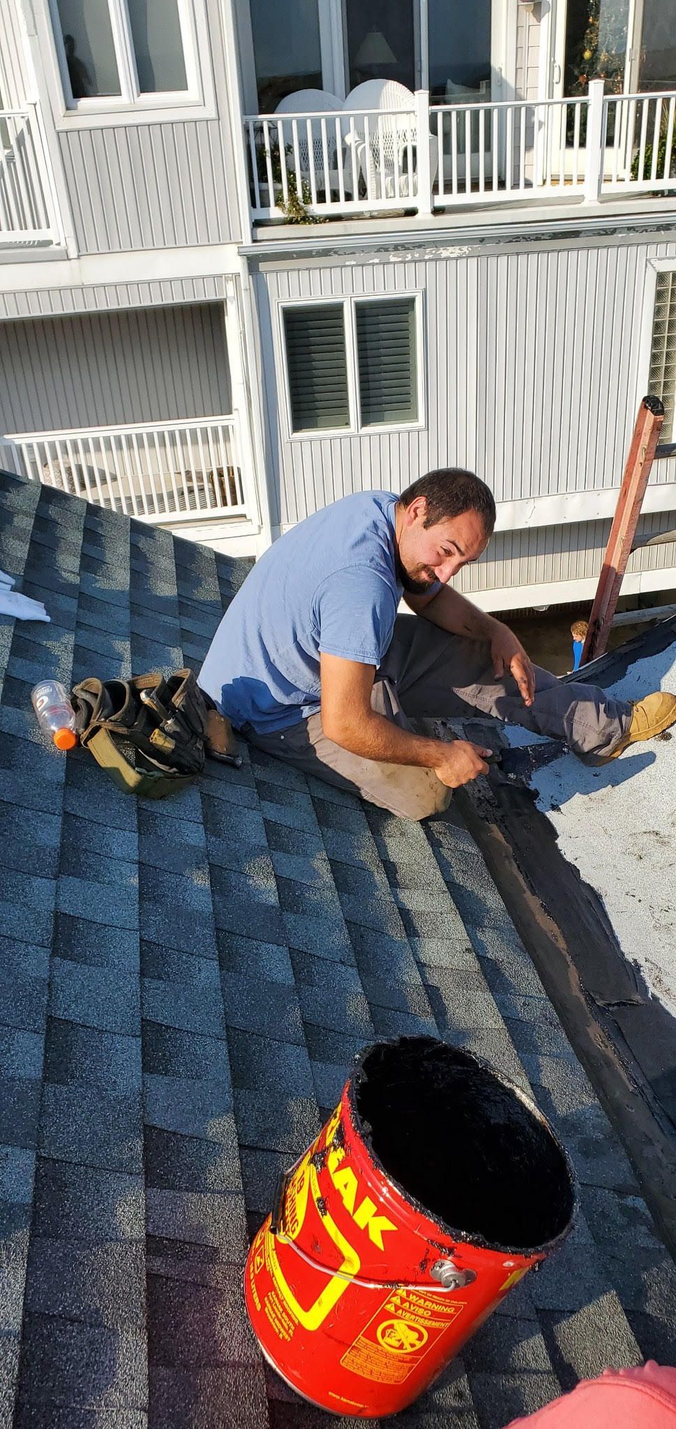 A man is working on the roof of a house.