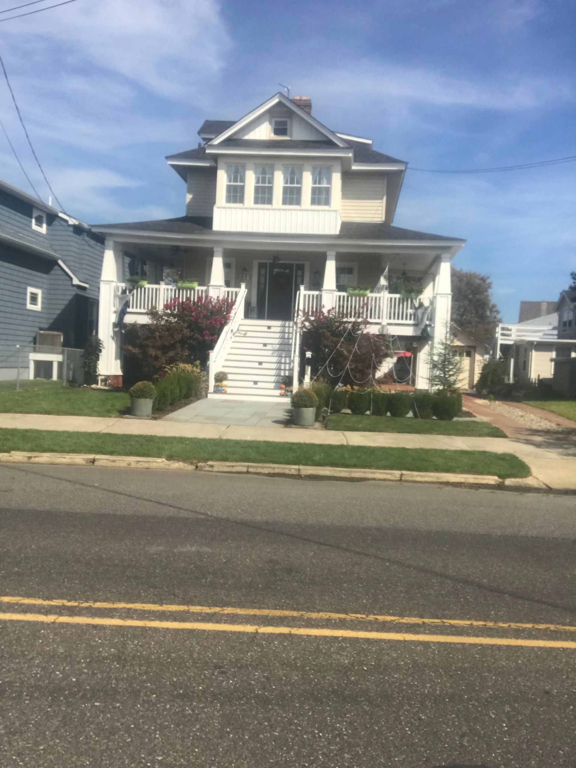 A large white house with a large porch and stairs