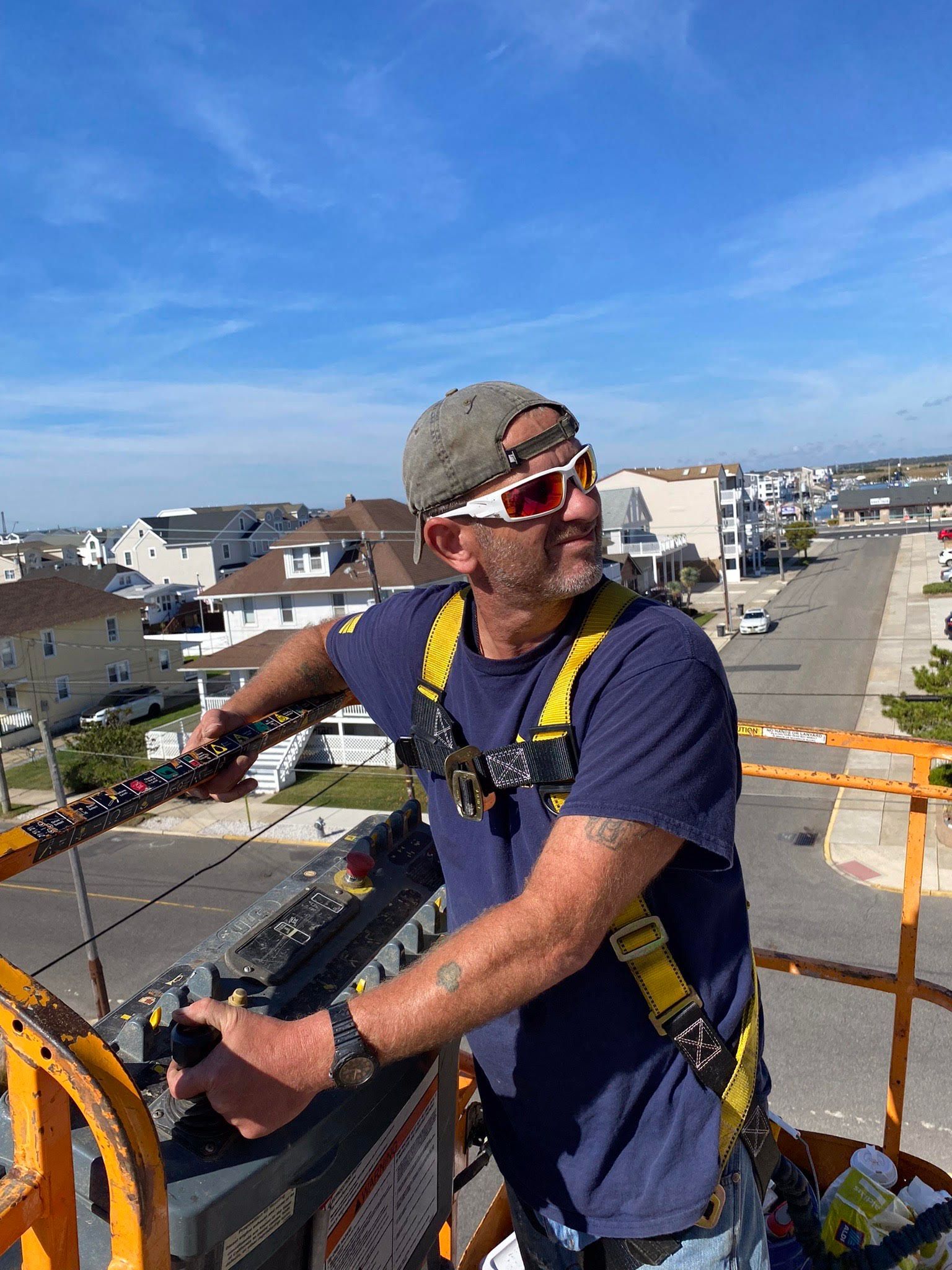 A man is standing on top of a crane.