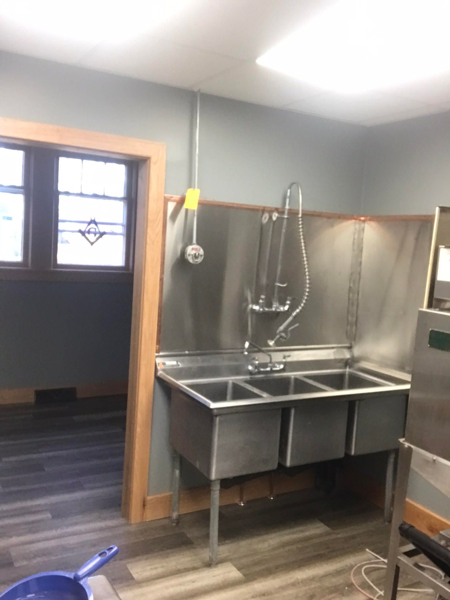 A kitchen with a stainless steel sink and a window.