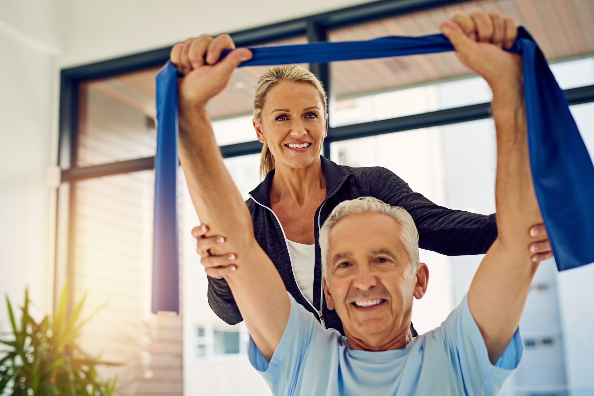 A man and a woman are doing exercises with a resistance band.