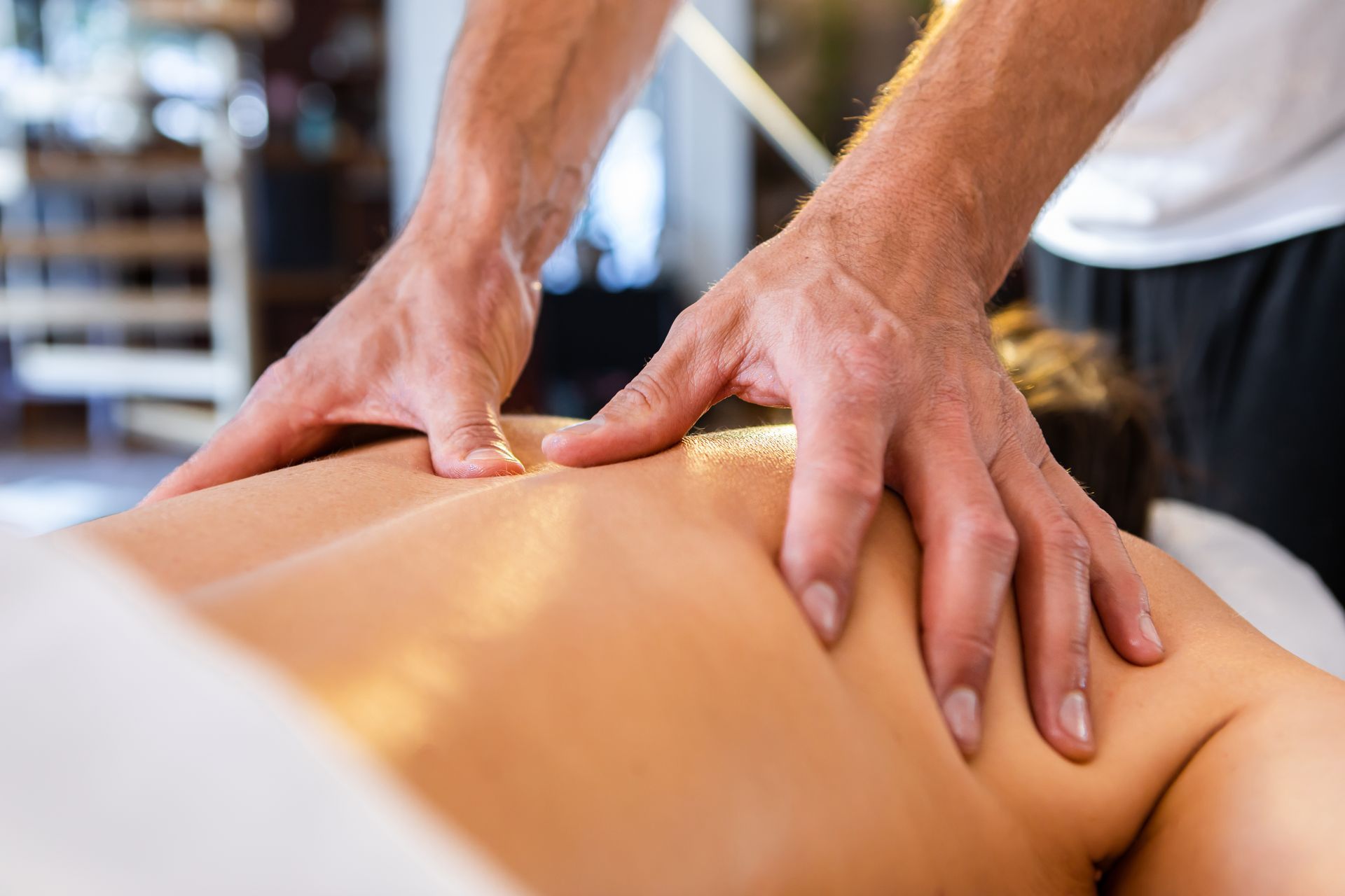 A man is giving a woman a massage on her back.