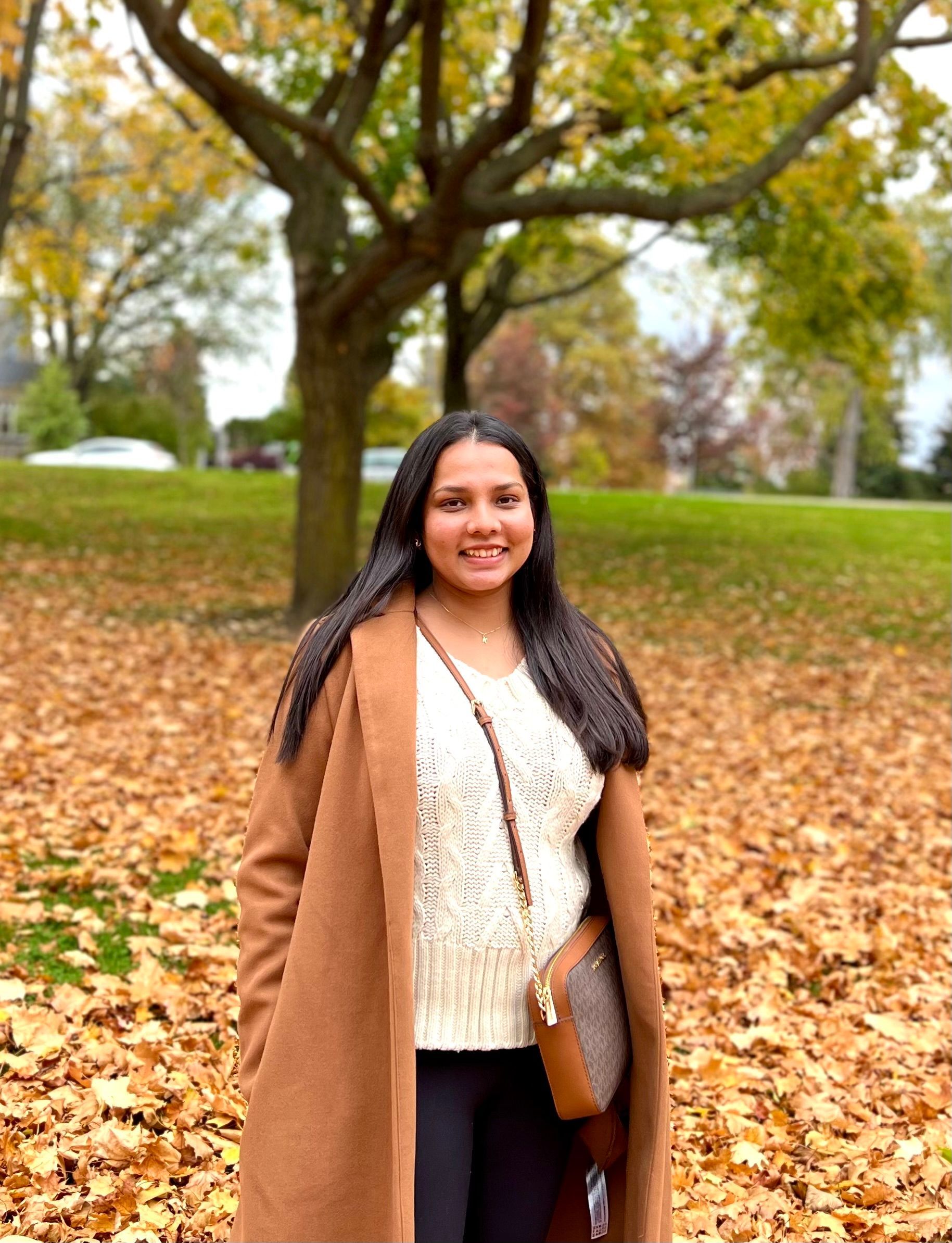 A bald man with a beard is smiling with his arms crossed.