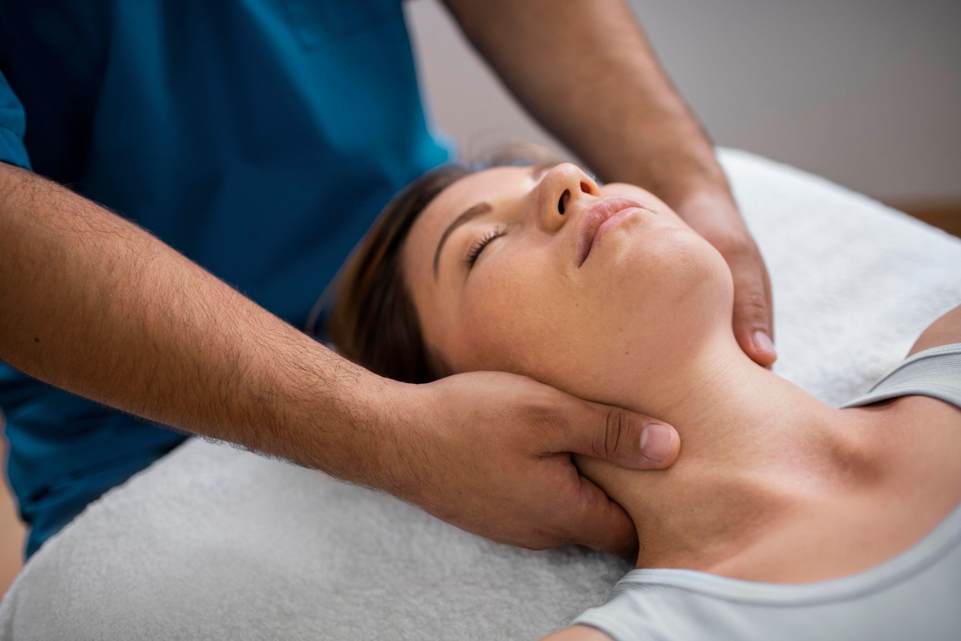 A woman is getting a neck massage from a man.