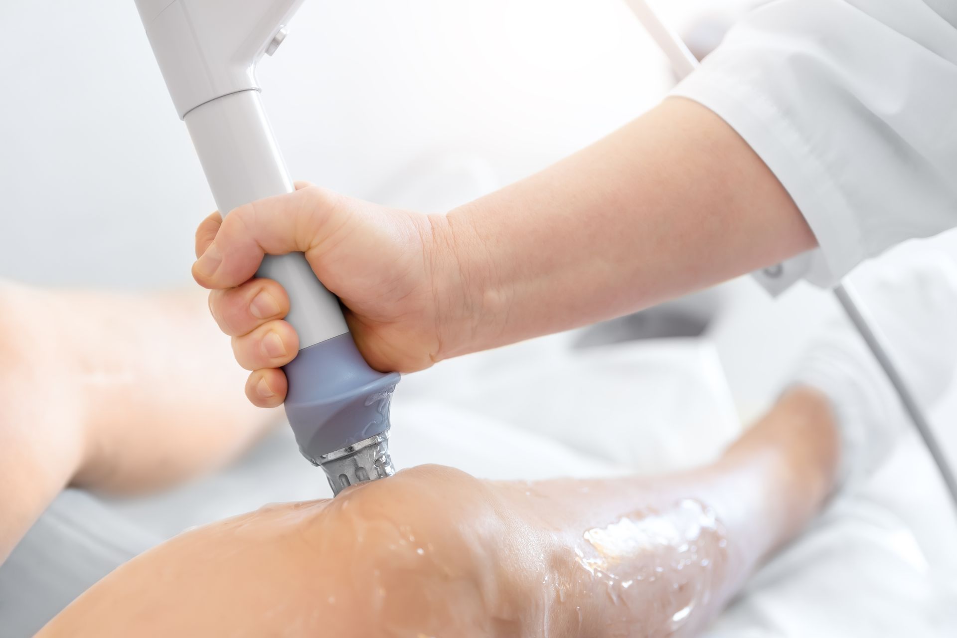 A person is getting a treatment on their leg with a machine.