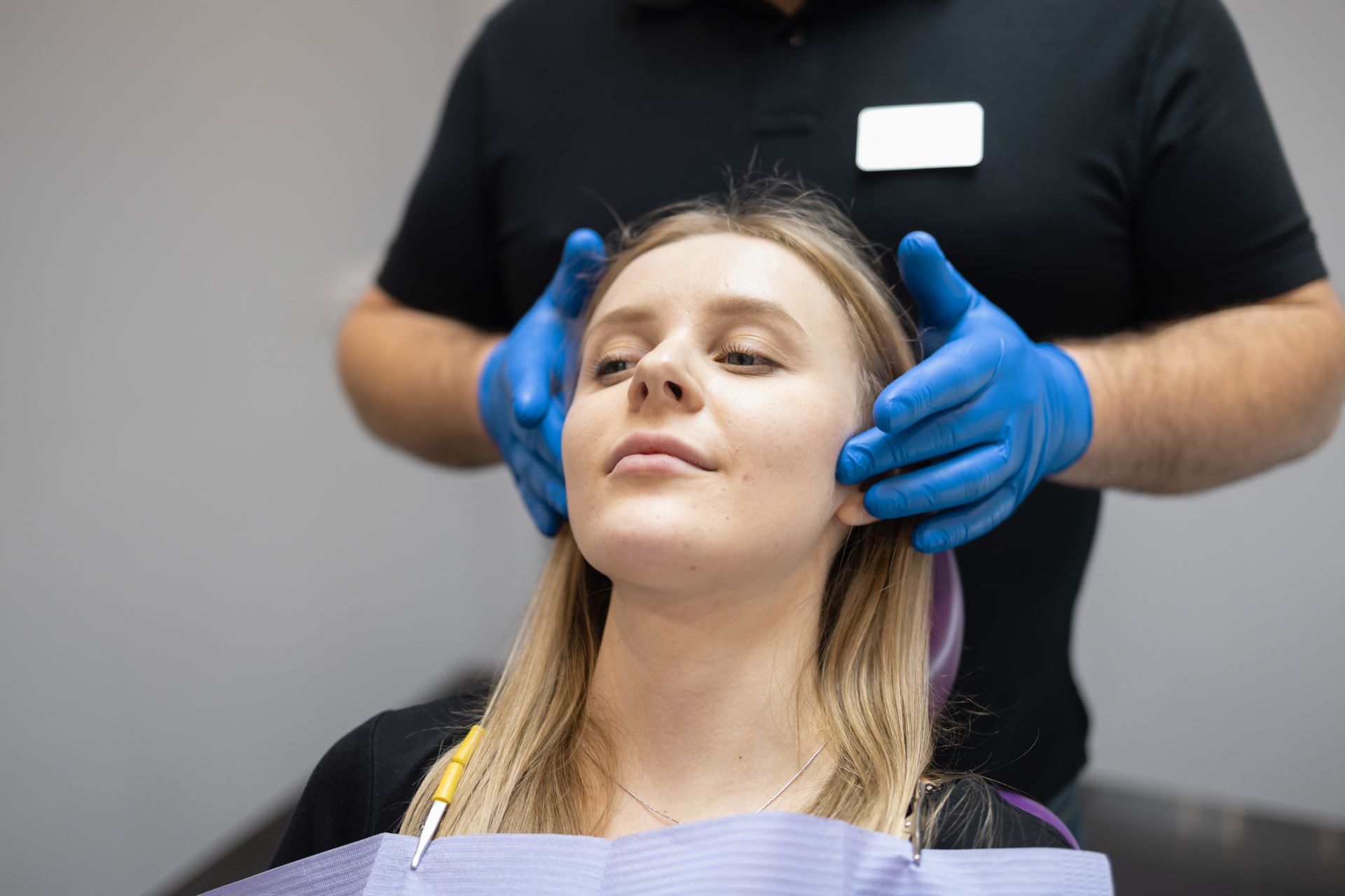 A woman is getting her ears examined by a dentist in a dental office.