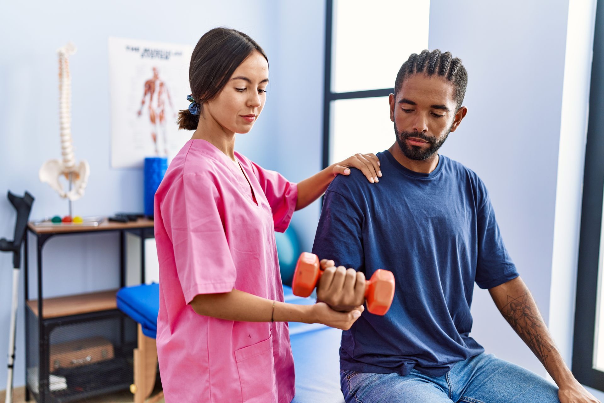 A woman is helping a man lift a dumbbell.