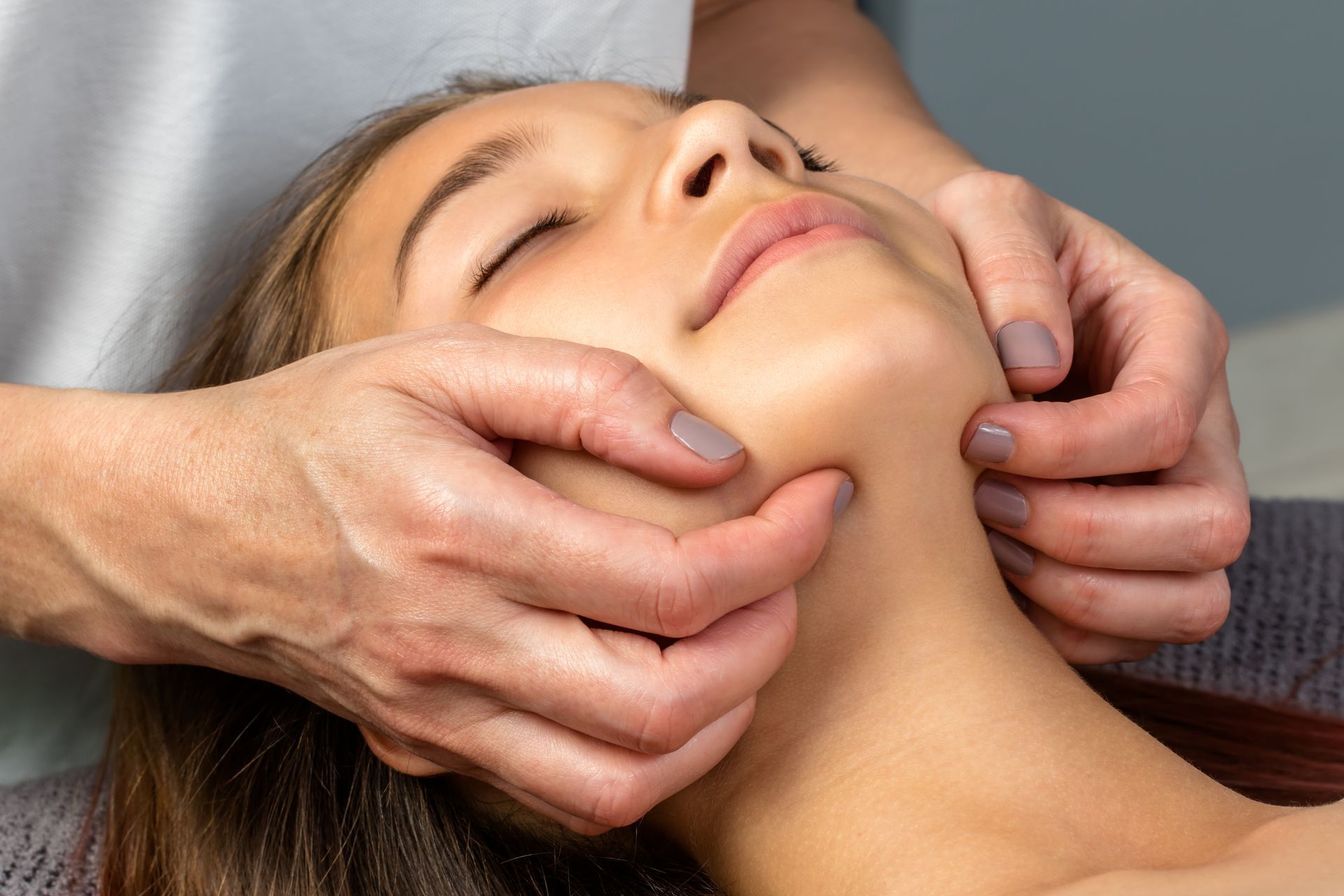 A woman is getting a massage on her face.