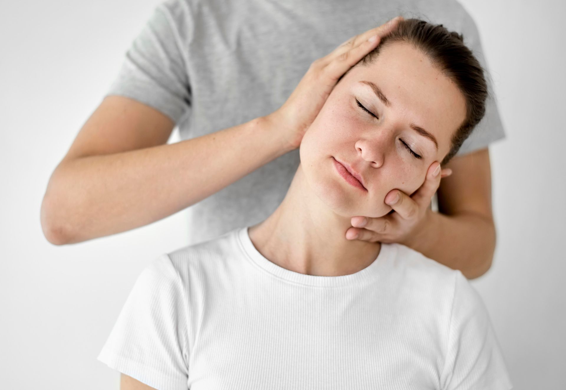 A woman is getting a neck massage from a man.