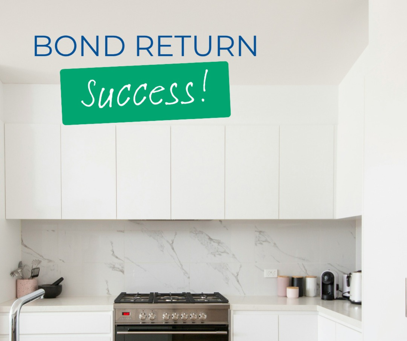 Kitchen with “Bond Return Success!” sign above white cabinets and stove