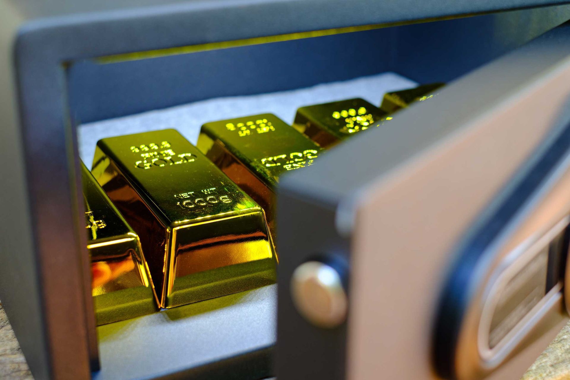Gold bars stacked inside an open safe.