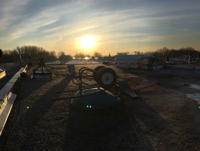 Un coucher de soleil sur un toit avec une brouette dessus