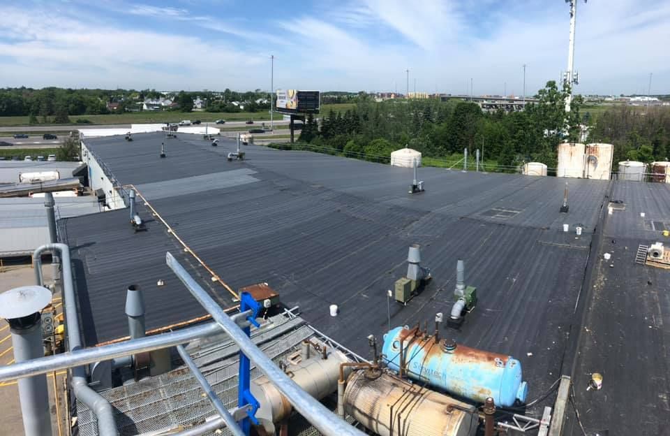 Le toit d'un bâtiment avec beaucoup de tuyaux dessus.