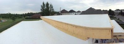 Un toit blanc est en train d'être construit sur une maison.