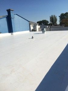 Un toit blanc avec un bâtiment bleu en arrière-plan.