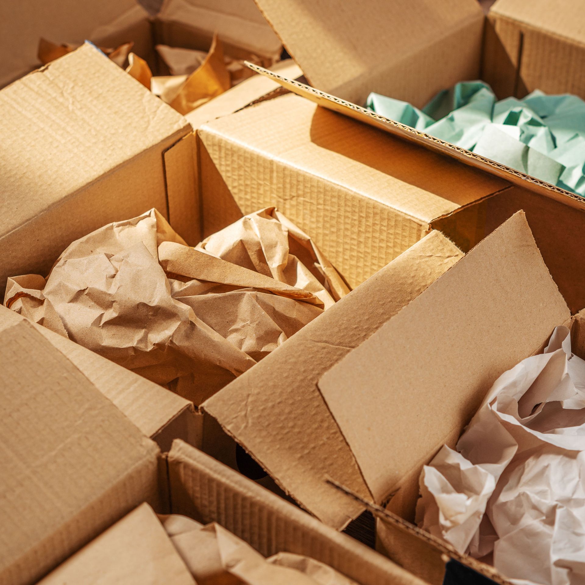Cardboard boxes with crumpled paper and packaging.