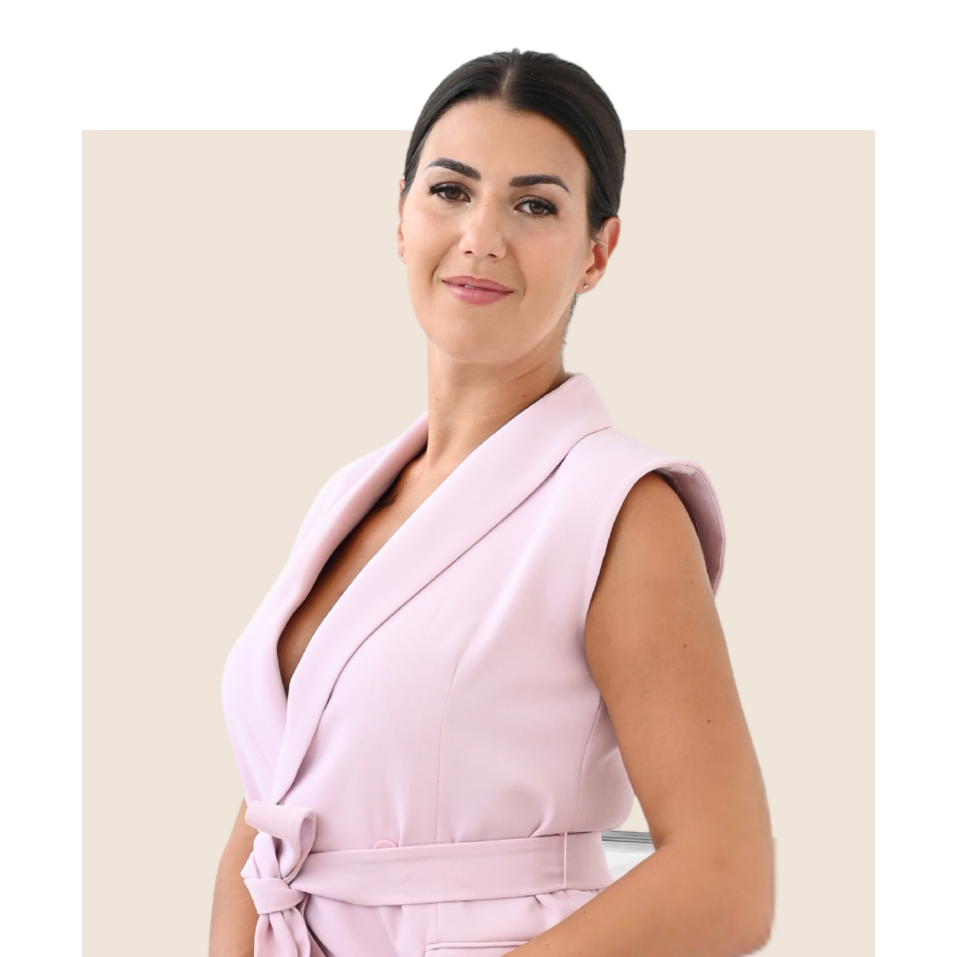 Woman in pink sleeveless blazer, smiling, indoors.