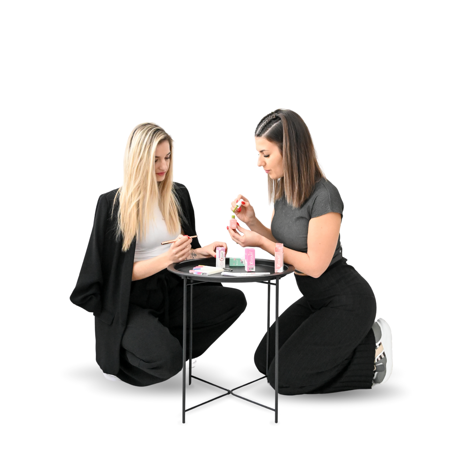 Two women at a small table doing a manicure.