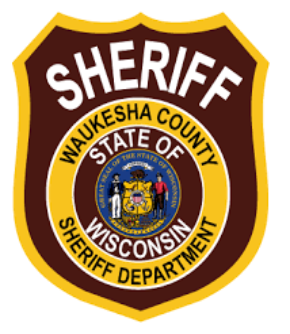 Waukesha County Sheriff's Department badge: brown and gold shield with text and a seal of Wisconsin.