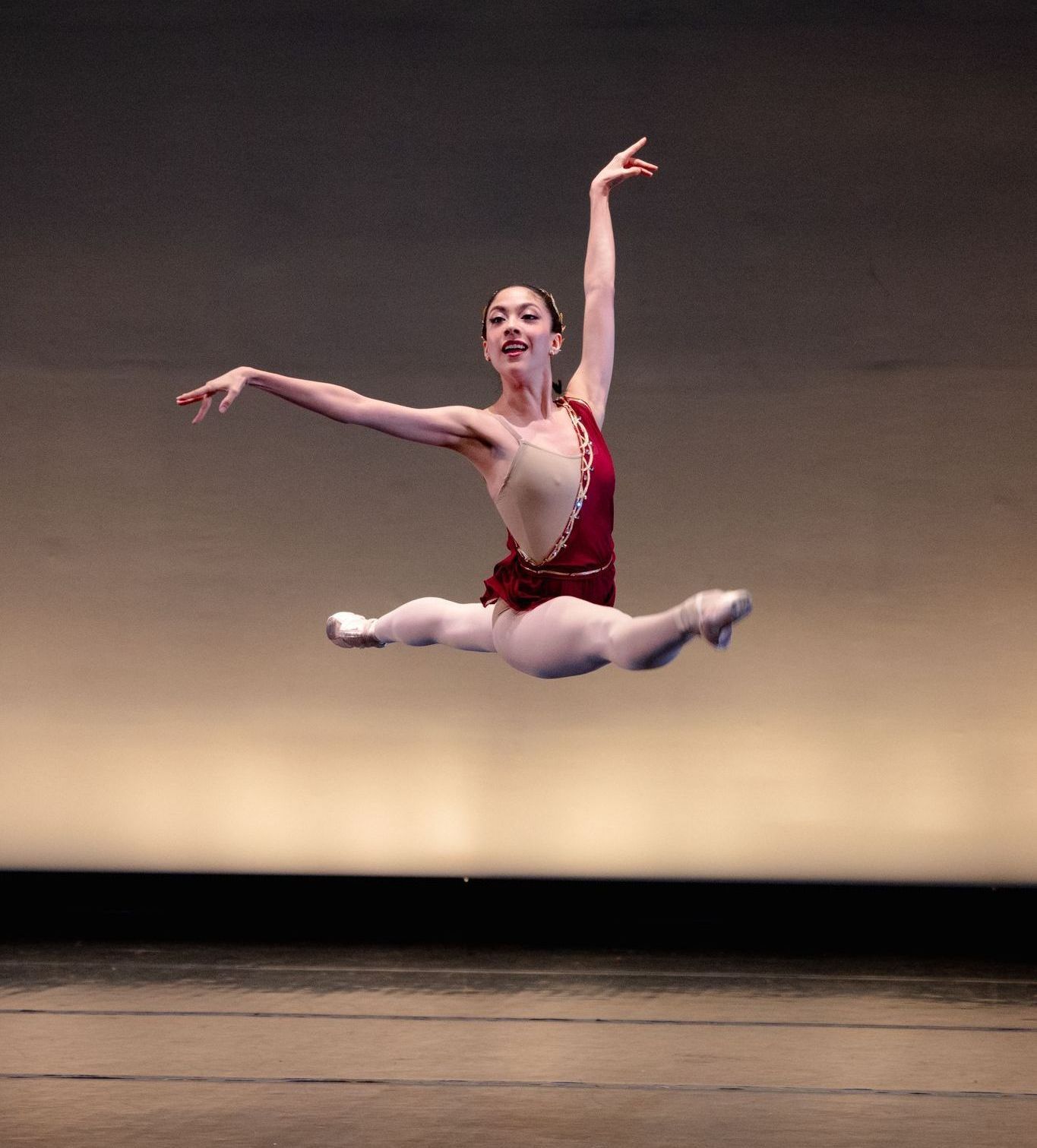 A woman is jumping in the air on a stage.