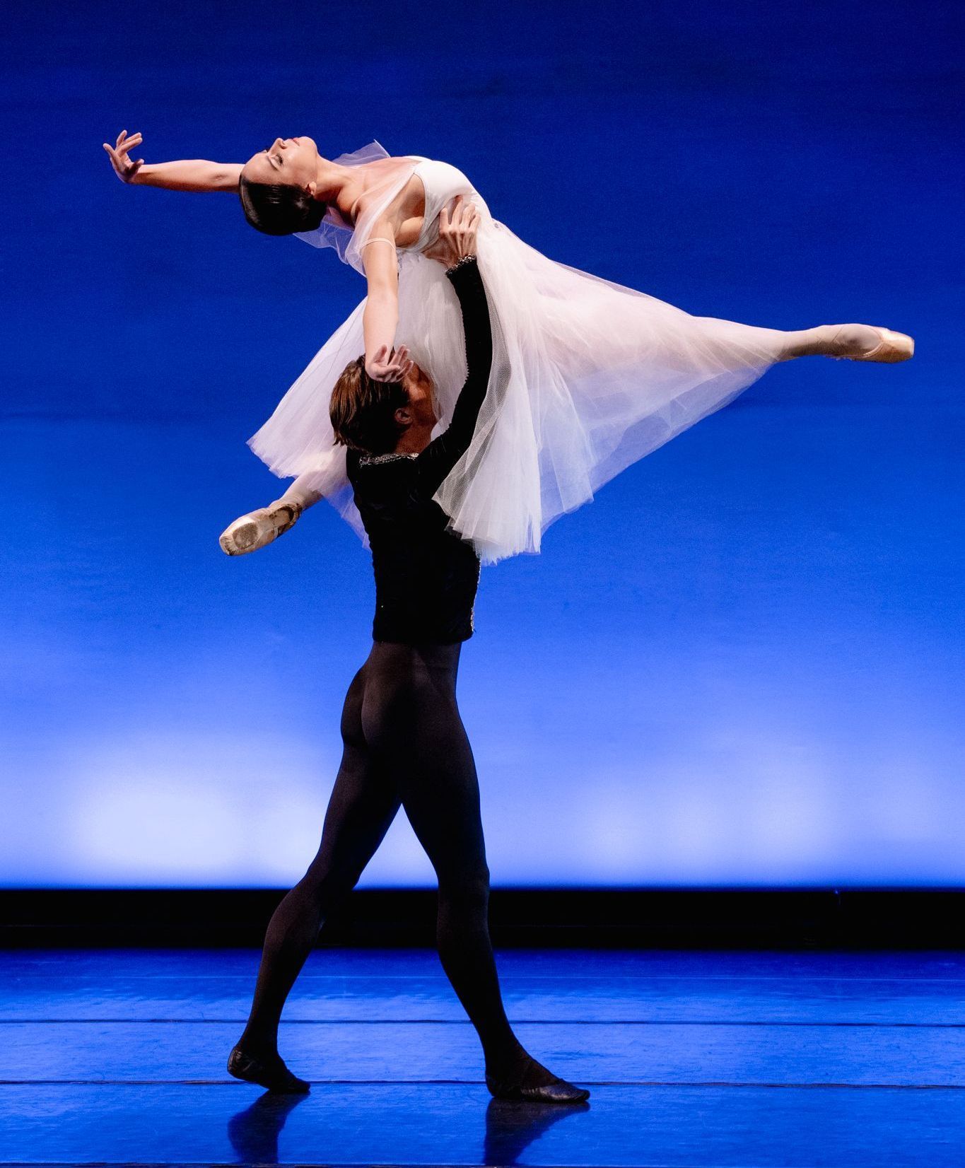 A man is holding a woman in his arms on a stage