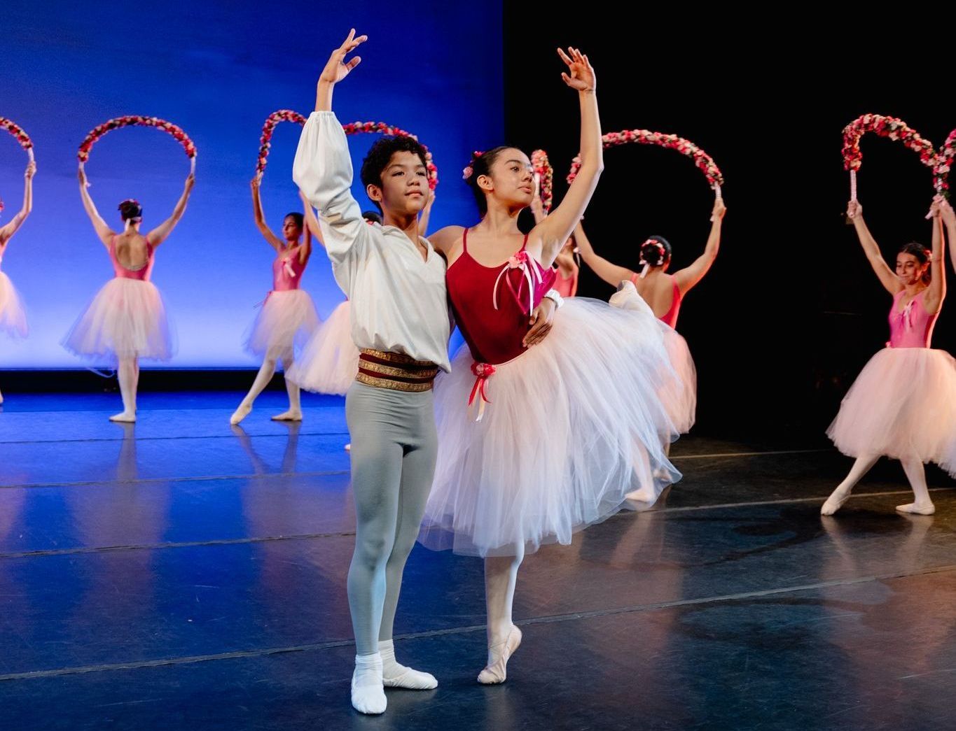 A group of ballet dancers are performing on a stage