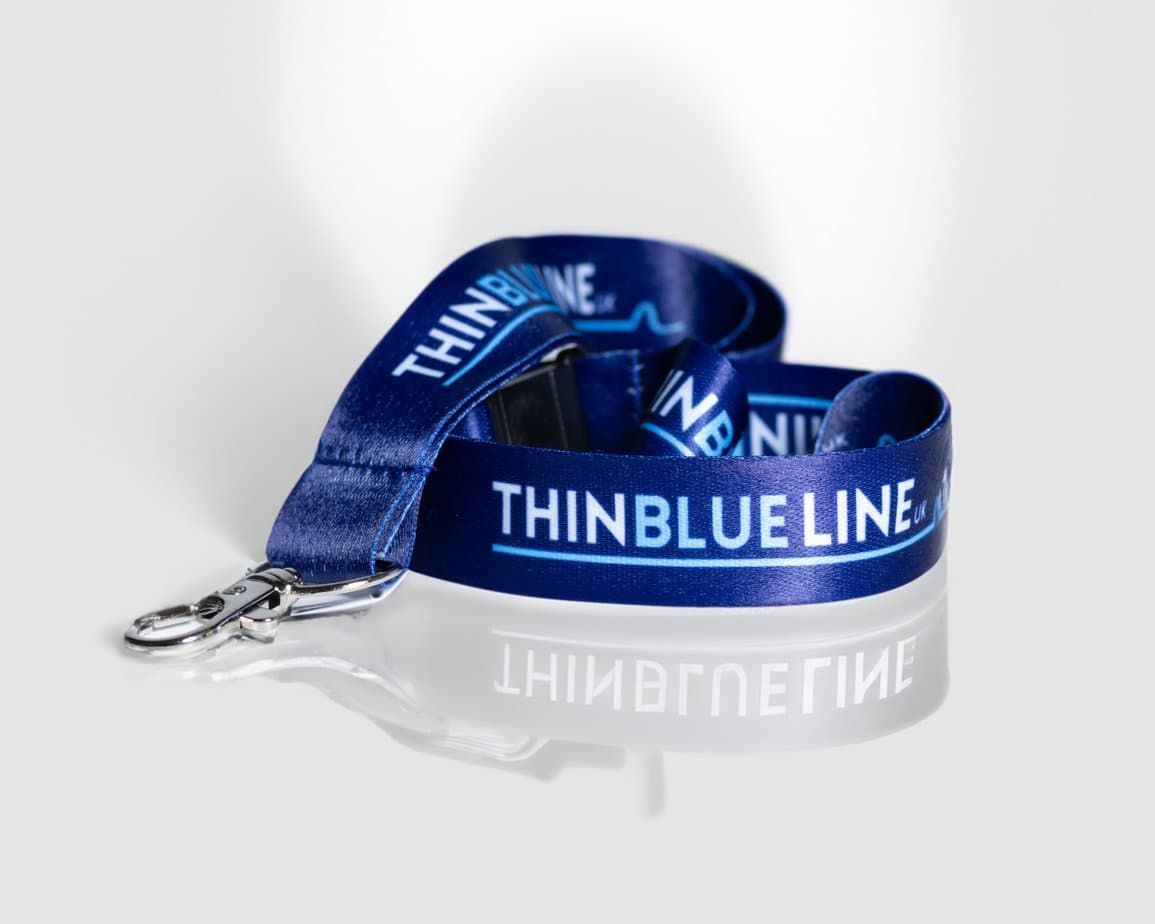 Dark blue "Thin Blue Line" lanyard, with a metal clasp, on a reflective surface.
