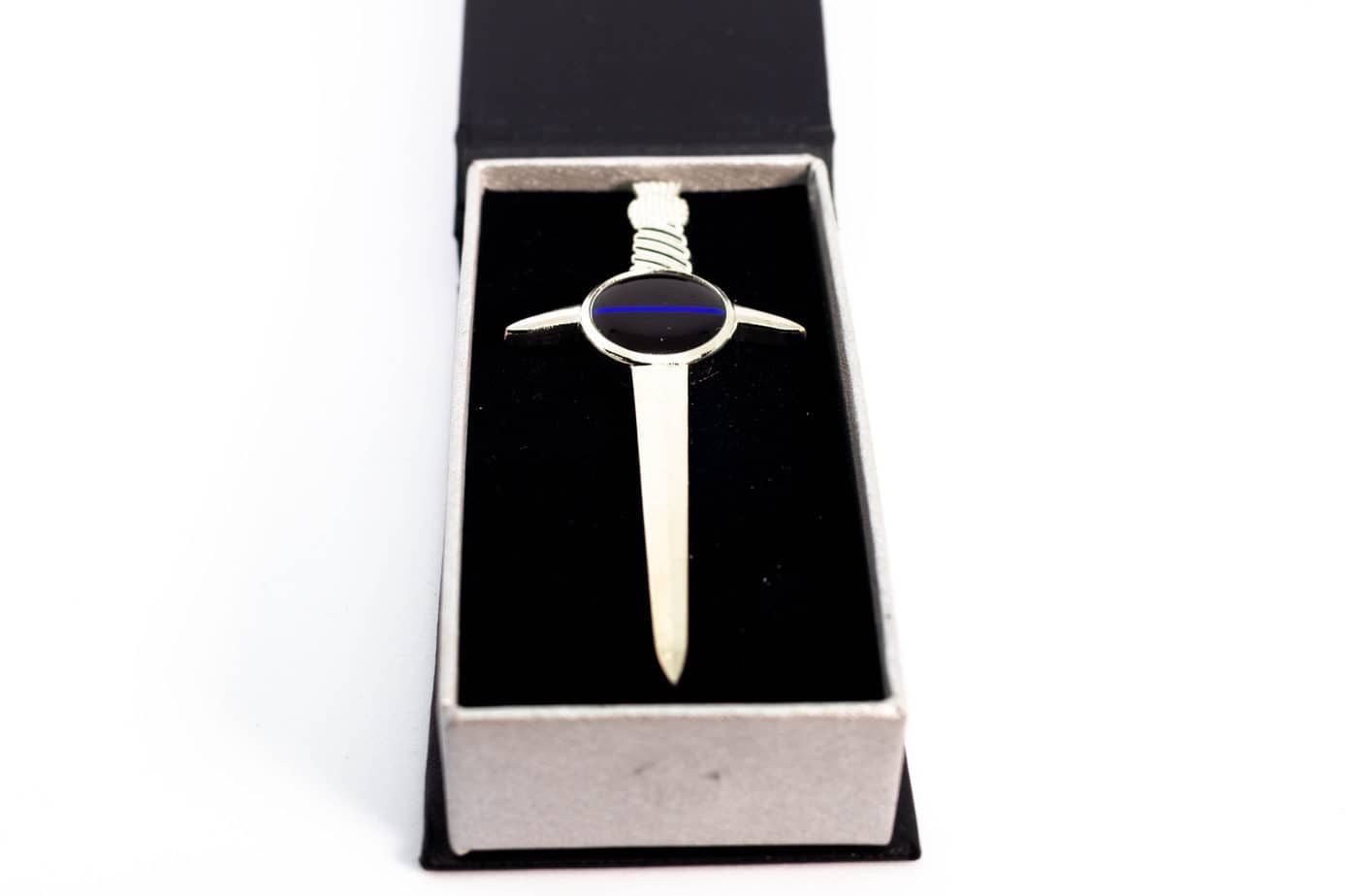 Silver lapel pin shaped like a sword with a blue stripe in a black velvet box.