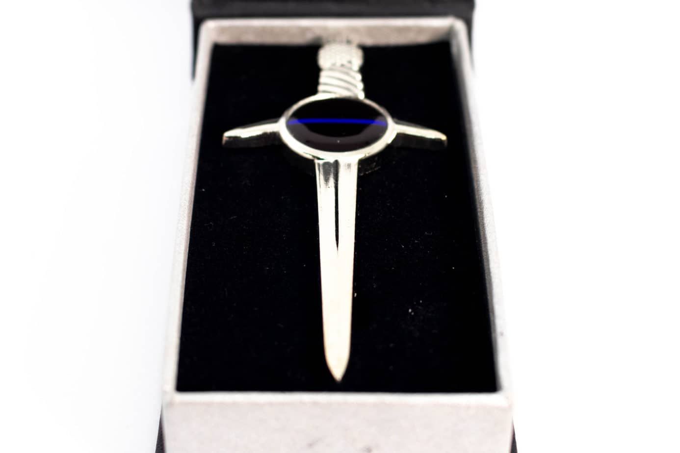 Silver lapel pin shaped like a sword with a blue stripe in a black velvet box.