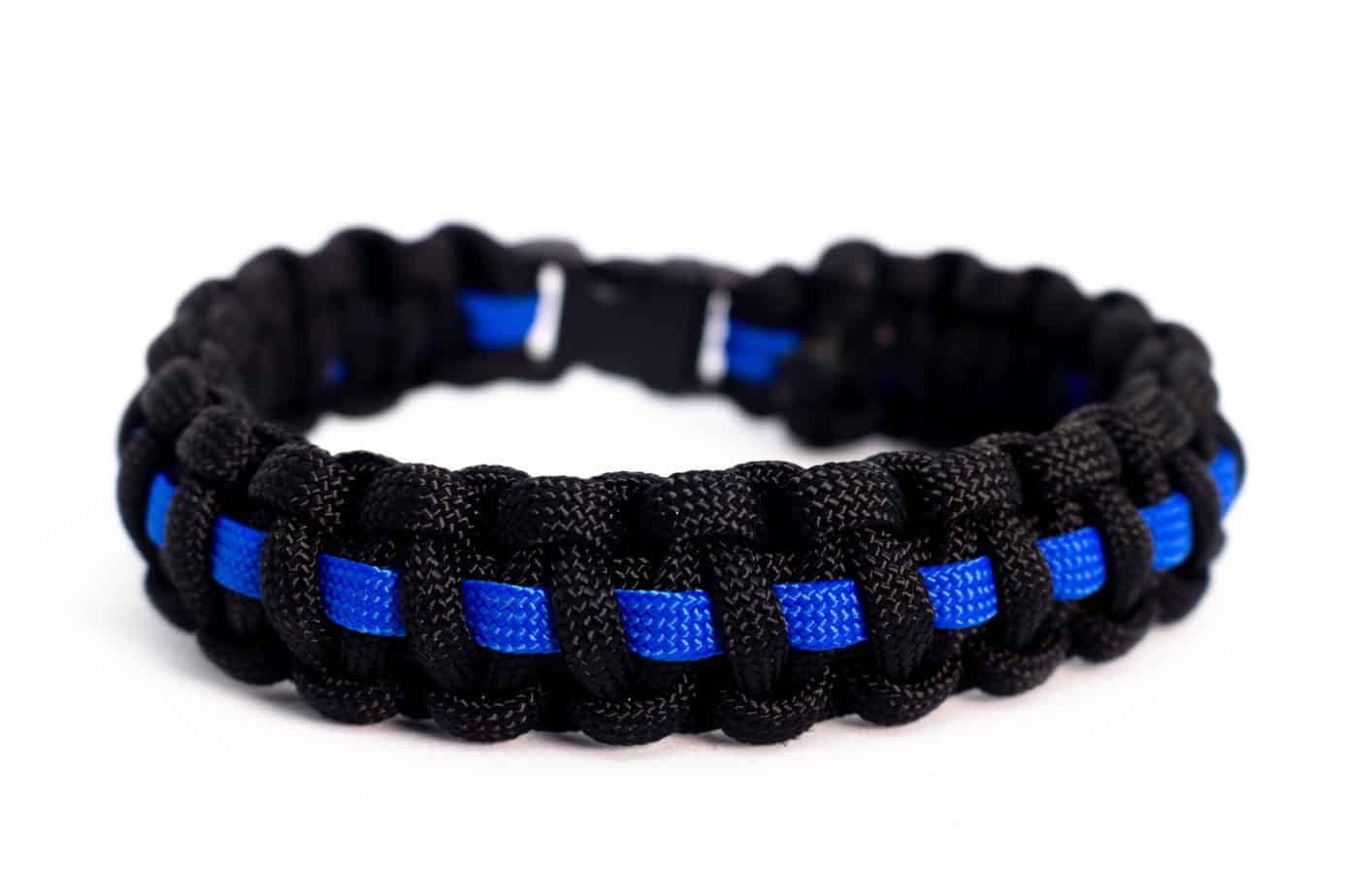 Black and blue paracord bracelet with a blue stripe, clasp fastened.