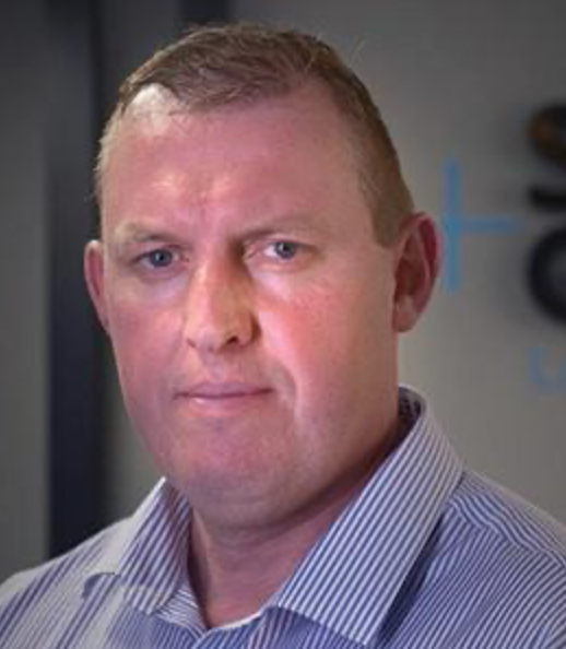 Man in blue striped shirt looking directly at the camera.