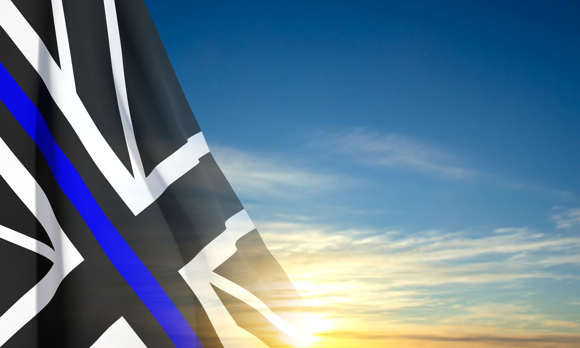 Thin Blue Line Union Jack flag waving against a blue sky with sunlight.