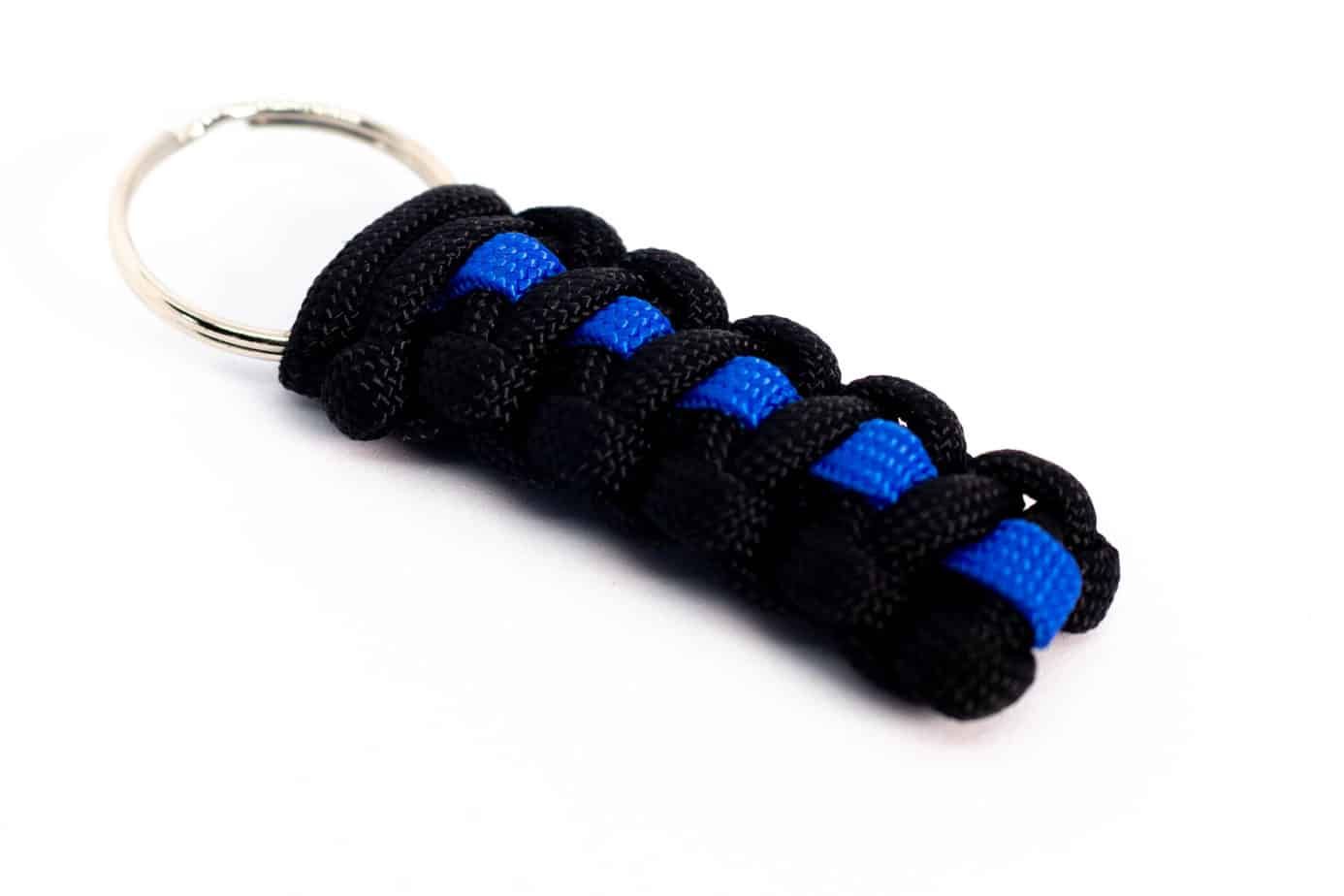 Black and blue braided paracord keychain on a white background.