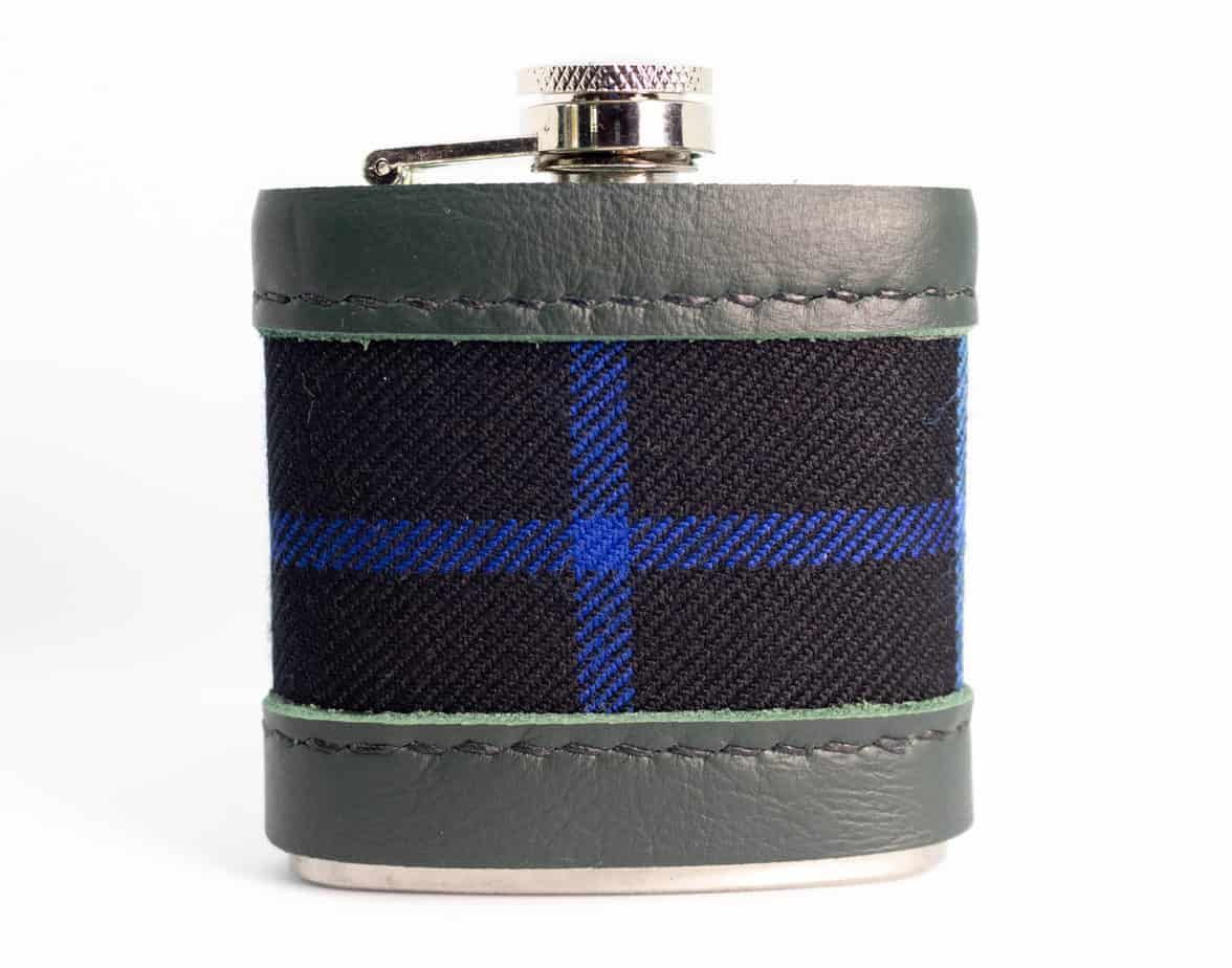 Flask with black and blue plaid center, green leather top and bottom, and a silver cap.