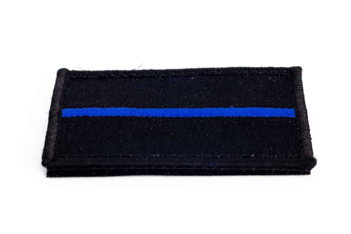 Black rectangle patch with a blue line, representing support for law enforcement.