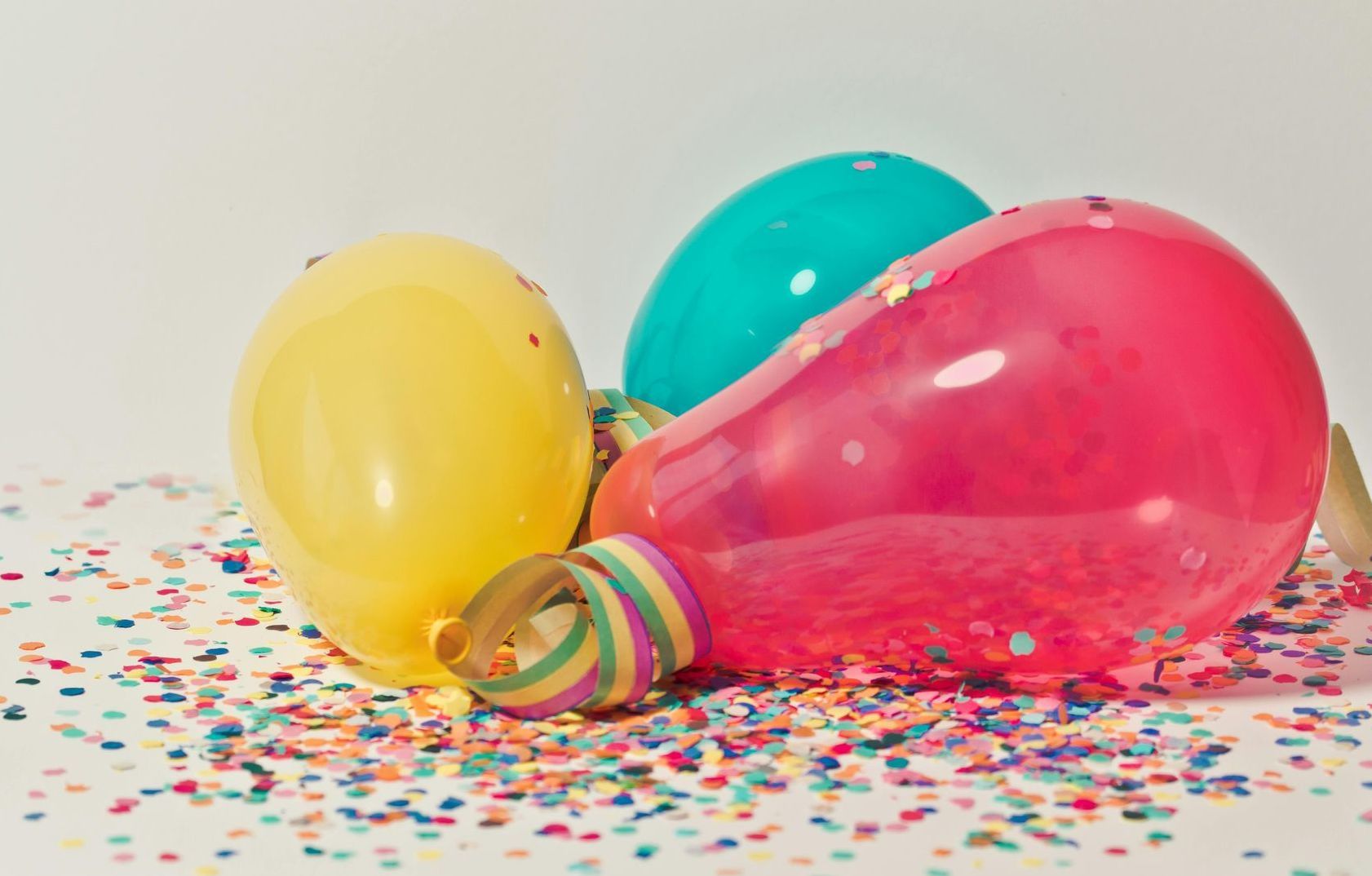 Colorful balloons with confetti, suggesting a party or celebration.